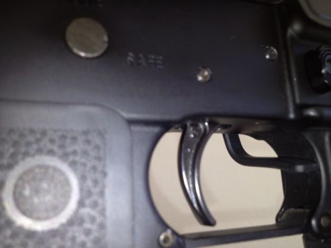 2013 Ford Mustang - Detail of a firearm's trigger and safety mechanism, showing the word 'SAFE' stamped on the receiver.
