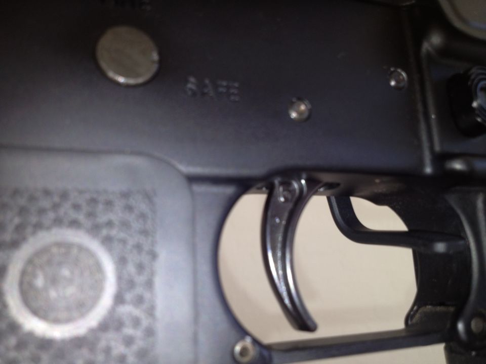 Close-up of firearm trigger assembly with 'SAFE' marking