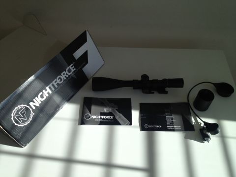 2013 Ford Mustang - Nightforce rifle scope and accessories laid out on a white surface.