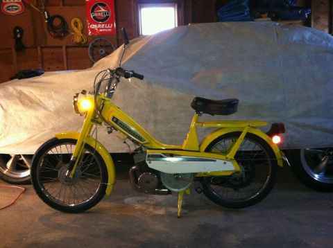 1981 Garelli Rally Sport - A yellow moped is parked in a garage next to a covered vehicle.