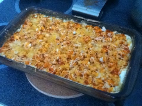 2006 Ford E350 - A baked casserole dish filled with food and topped with melted cheese sits on a stovetop.