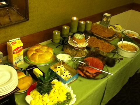 2006 Ford E350 - A buffet spread features roast beef, a large round bread, fruit salad, and decorative candles.