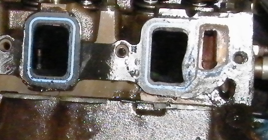 Engine intake manifold gasket surface with two rectangular openings and gasket material