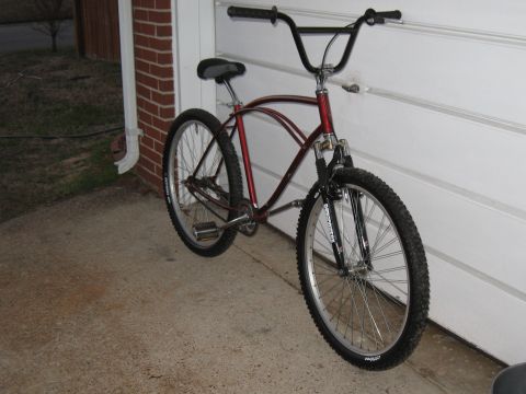 1994 Ford Bronco - A red bicycle with wide handlebars is parked next to a garage door.