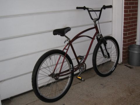 1994 Ford Bronco - A cruiser bicycle with wide tires and a curved frame is parked on a concrete surface in front of a garage door.