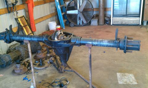 1995 Ford Bronco - Differential axle assembly with exposed gears and axle shafts is displayed on stands in a workshop.