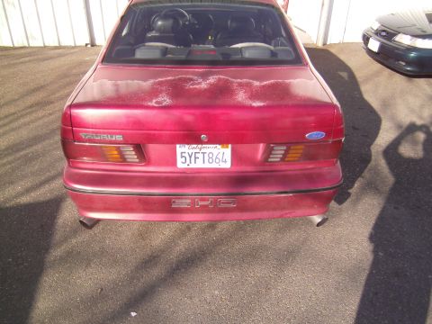 1991 Ford Taurus - Rear view of a red 1991 Ford Taurus SHO, showing the taillights and license plate.