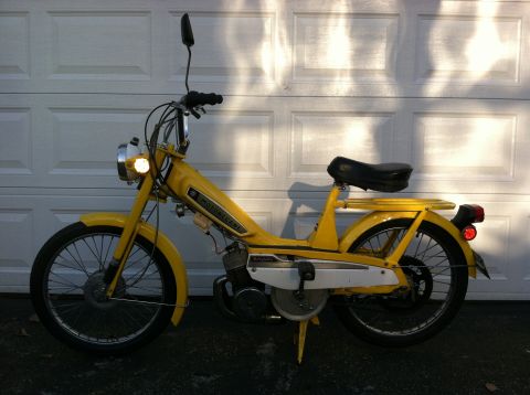 1981 Garelli Rally Sport - This yellow moped, identified as a Motobecane, is shown from the side in front of a closed garage door.