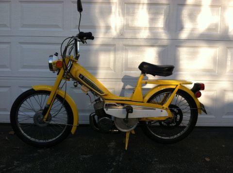 1981 Garelli Rally Sport - Yellow moped with 'MOTOBECANE' branding parked in front of a garage door.
