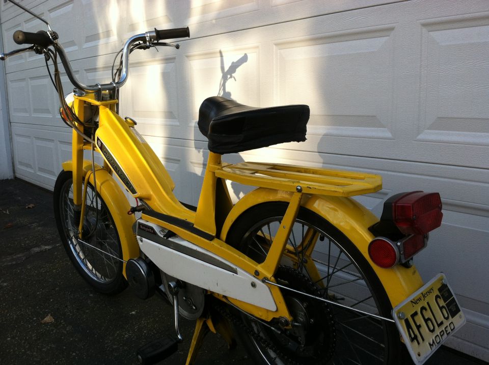 Yellow moped side view with New Jersey plate AF6L6