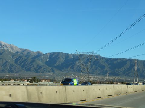 2003 Ford Crown Victoria - View through windshield of freeway traffic, a steel transmission pylon and a long mountain ridge