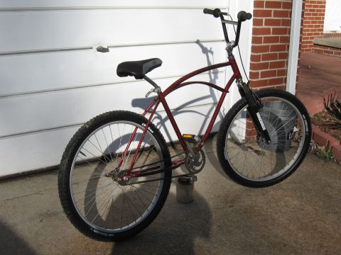 1994 Ford Bronco - A red cruiser bicycle is parked outdoors in front of a white garage door.