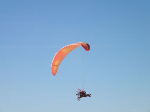2003 Ford Crown Victoria - Powered paraglider with an orange wing carries a pilot on a wheeled trike aloft