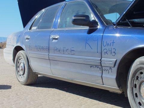 2003 Ford Crown Victoria - Door and rear panel of a blue Crown Victoria covered in marker reading EL MIRAGE POLICE and K9 Unit 243.