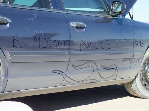 2003 Ford Crown Victoria - Close-up of a dark sedan door hand-lettered EL MIRAGE POLICE, K9 Unit 243 above a marker flame design.