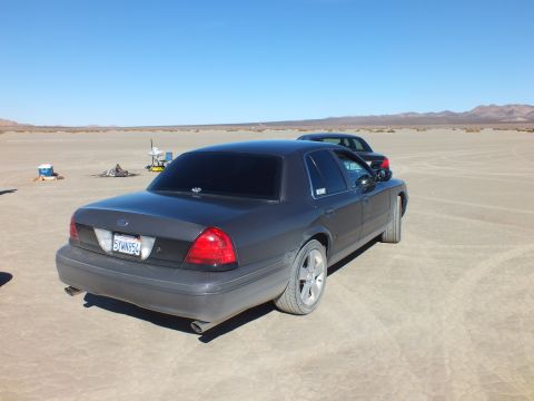 2003 Ford Crown Victoria - Tail-end view of a Crown Victoria showing Ford oval, California plate 6YWN854 and dual lit taillights.