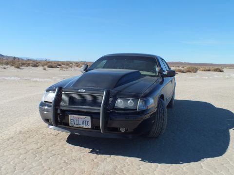 2003 Ford Crown Victoria - Front of a black Crown Victoria fitted with a chrome push bar guard and EVIL VIC California plate.