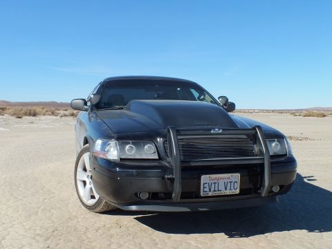 2003 Ford Crown Victoria - Close front view of the black Crown Victoria, chrome brush guard framing the grille and EVIL VIC plate.