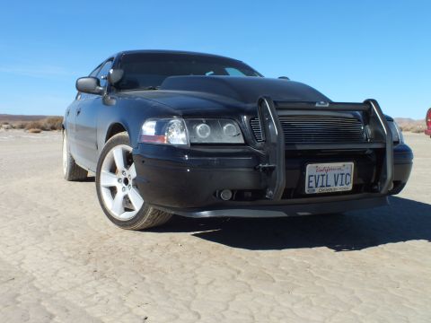 2003 Ford Crown Victoria - Tight front quarter of the black EVIL VIC Crown Victoria with brush guard and side mirror in frame.