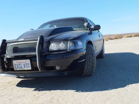 2003 Ford Crown Victoria - Low shot of the black Crown Victoria; plate frame reads CROWN VICTORIA below the EVIL VIC plate.