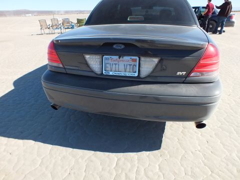 2003 Ford Crown Victoria - Gray Crown Victoria rear view showing SVT emblem, dual exhaust tips and a California plate reading EVT VTC.