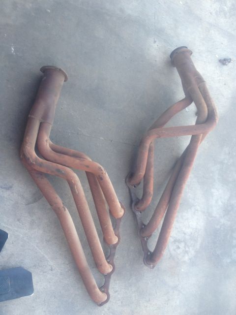 1964 Ford Ranchero - A pair of used exhaust manifolds are shown resting on a concrete floor.