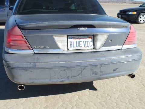 2003 Ford Crown Victoria - Rear of a gray Crown Victoria, BLUE VIC plate and POLICE written in dust on the bumper