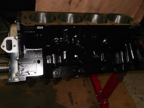 1965 Shelby Cobra - A black engine block is shown from the side, resting on a red engine stand.