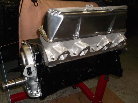 1965 Shelby Cobra - Engine assembly polished aluminum valve covers and a black block, mounted on a red engine stand.