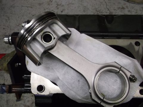 1965 Shelby Cobra - Engine part assembly, a piston and connecting rod, is shown close up against a dark engine block.