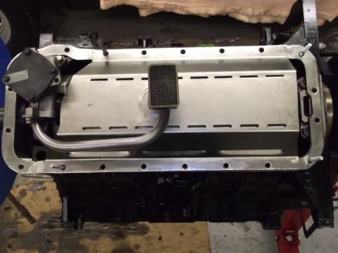 1965 Shelby Cobra - Close-up view of an engine's oil pan assembly, showing the pickup tube and screen.