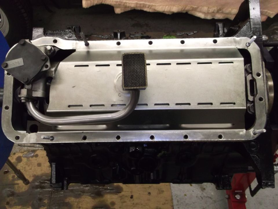 Engine oil pan with oil pickup tube and screen