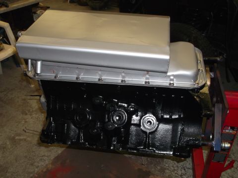1965 Shelby Cobra - A close-up view of an engine block and its oil pan, likely undergoing maintenance or assembly.