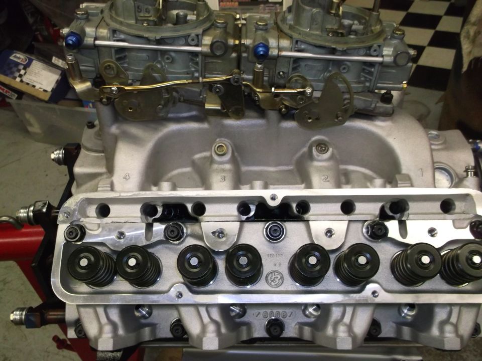 V8 engine block with dual carburetors and valve train visible