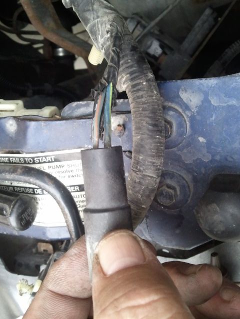 1994 Ford Bronco - Close-up of an engine wiring harness connector with exposed wires.