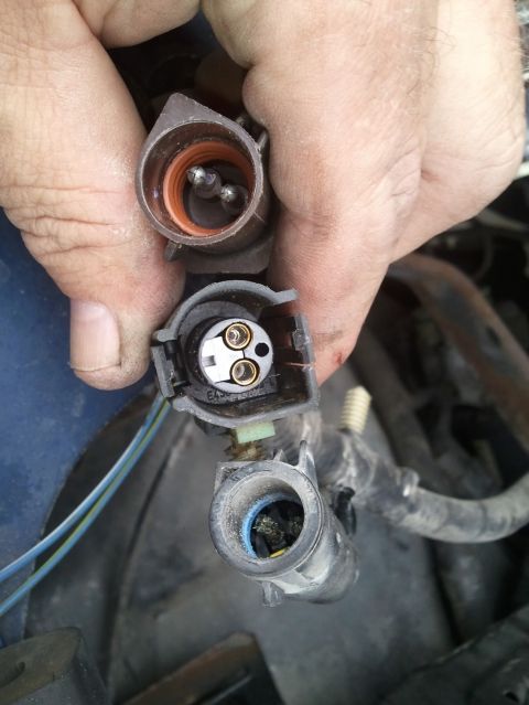 1994 Ford Bronco - Close-up of automotive electrical connectors being held, showing pins and sockets.