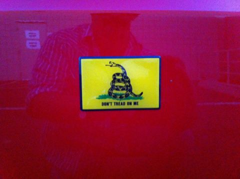 2010 Dodge Challenger - A Gadsden flag sticker is affixed to the red exterior of a vehicle.