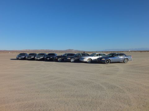2003 Ford Crown Victoria - Sedan meet parked in a row across desert hardpan under a clear sky
