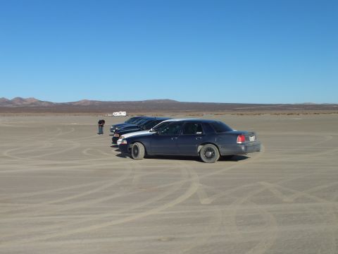 2003 Ford Crown Victoria - Lowered full-size sedan on desert hardpan with others lined up behind