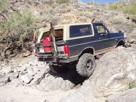 1993 Ford Bronco - This 1993 Ford Bronco navigates a challenging rocky terrain, equipped with off-road gear.