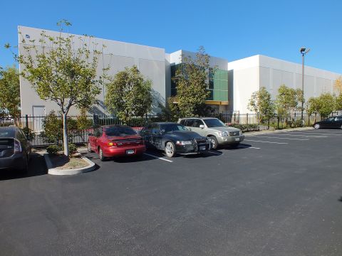 2003 Ford Crown Victoria - Parking lot row at a tan industrial building with a red coupe, dark sedan and silver SUV.