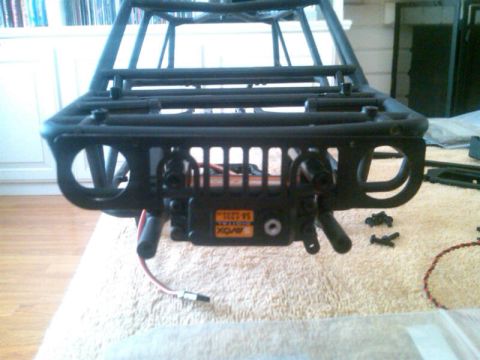 1986 Ford Bronco - RC car chassis front view showing the roll cage and a servo motor with visible text.