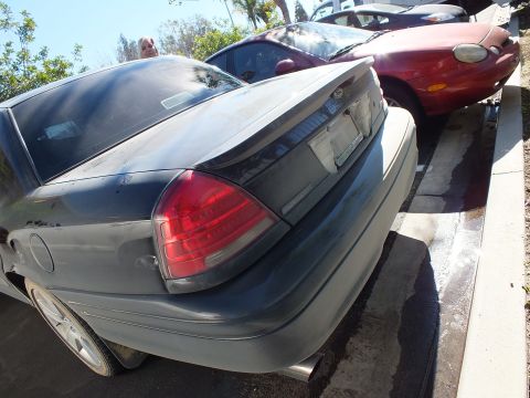 2003 Ford Crown Victoria - Rear deck of a Ford Crown Victoria sedan beside a red coupe in a parking lot.
