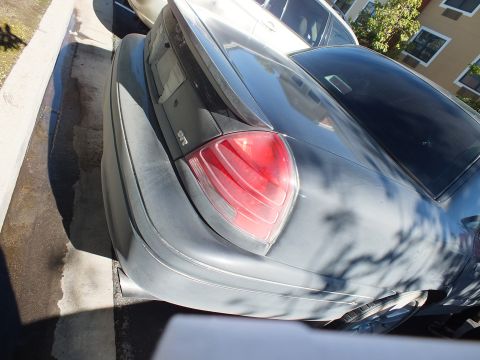 2003 Ford Crown Victoria - Angled overhead view of a dark Crown Victoria's trunk lid and red tail lens.