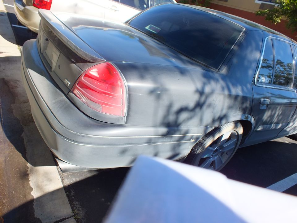 Dark Ford Crown Victoria rear three-quarter with tail light and alloy wheel