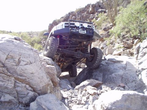 1993 Ford Bronco - This 1993 Ford Bronco navigates a challenging rocky trail, its off-road capabilities with a modified bumper and suspension.