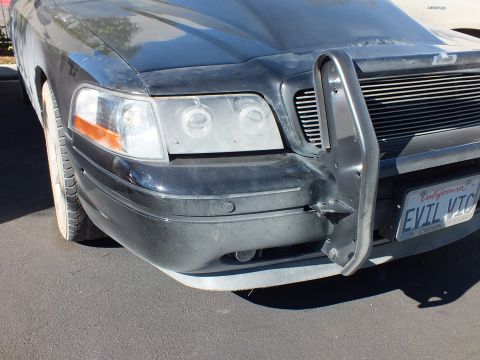 2003 Ford Crown Victoria - Front of a black Crown Victoria with push bumper, grille and California plate EVIL VIC.