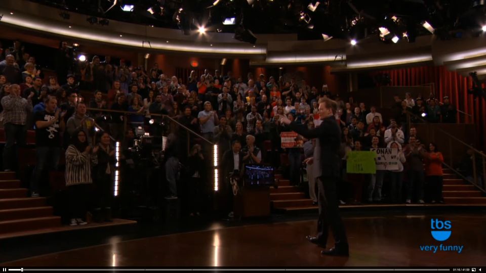 Studio audience in tiered seating watching a performance