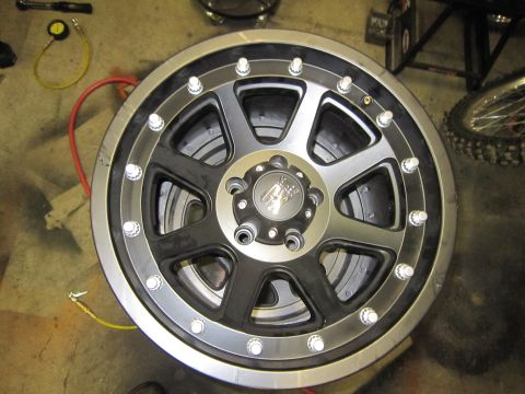 2008 Jeep Wrangler - Aftermarket wheel and tire assembly shown in a workshop setting.