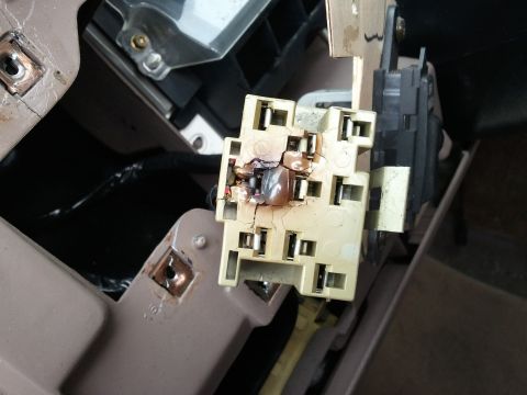 1994 Ford Bronco - A close-up view of a damaged electrical connector, indicating a potential wiring issue within the vehicle's interior.